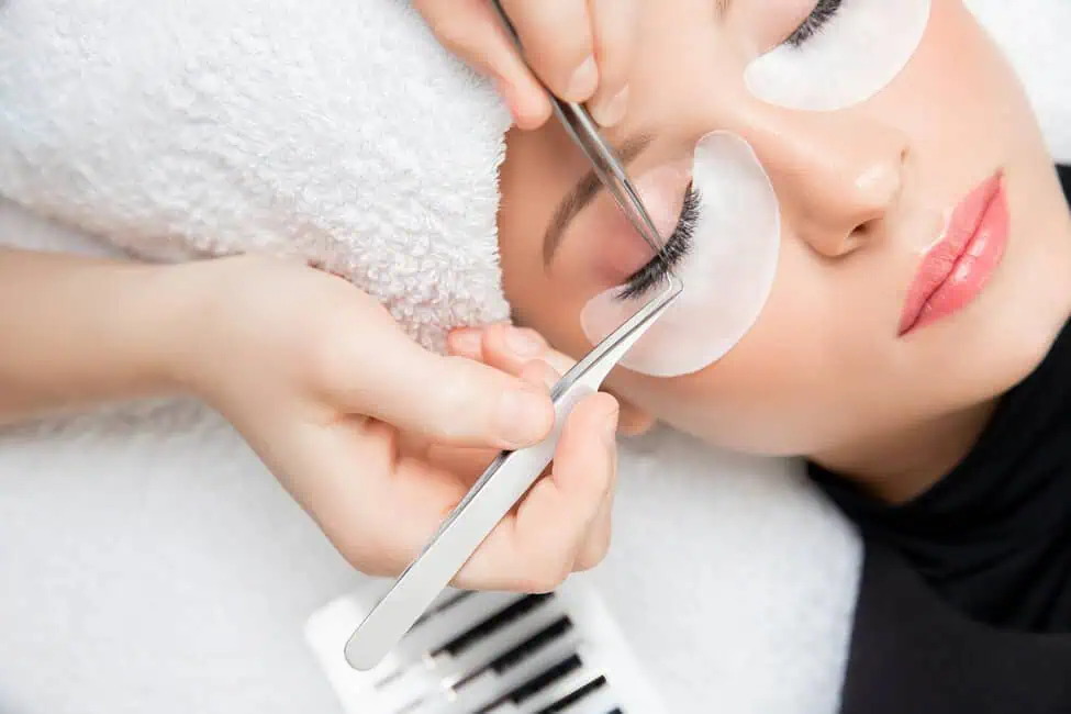 Woman receiving professional eyelash extension service at Haven Permanent Cosmetics & Aesthetics in Gig Harbor, WA